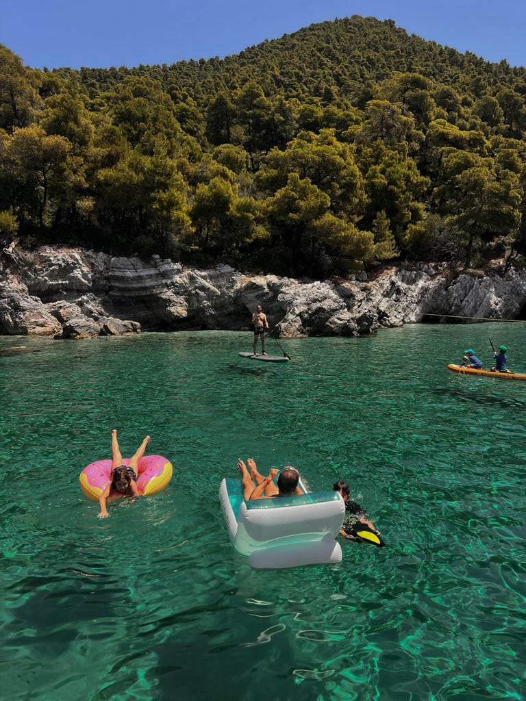 People enjoying sun next to forested island
